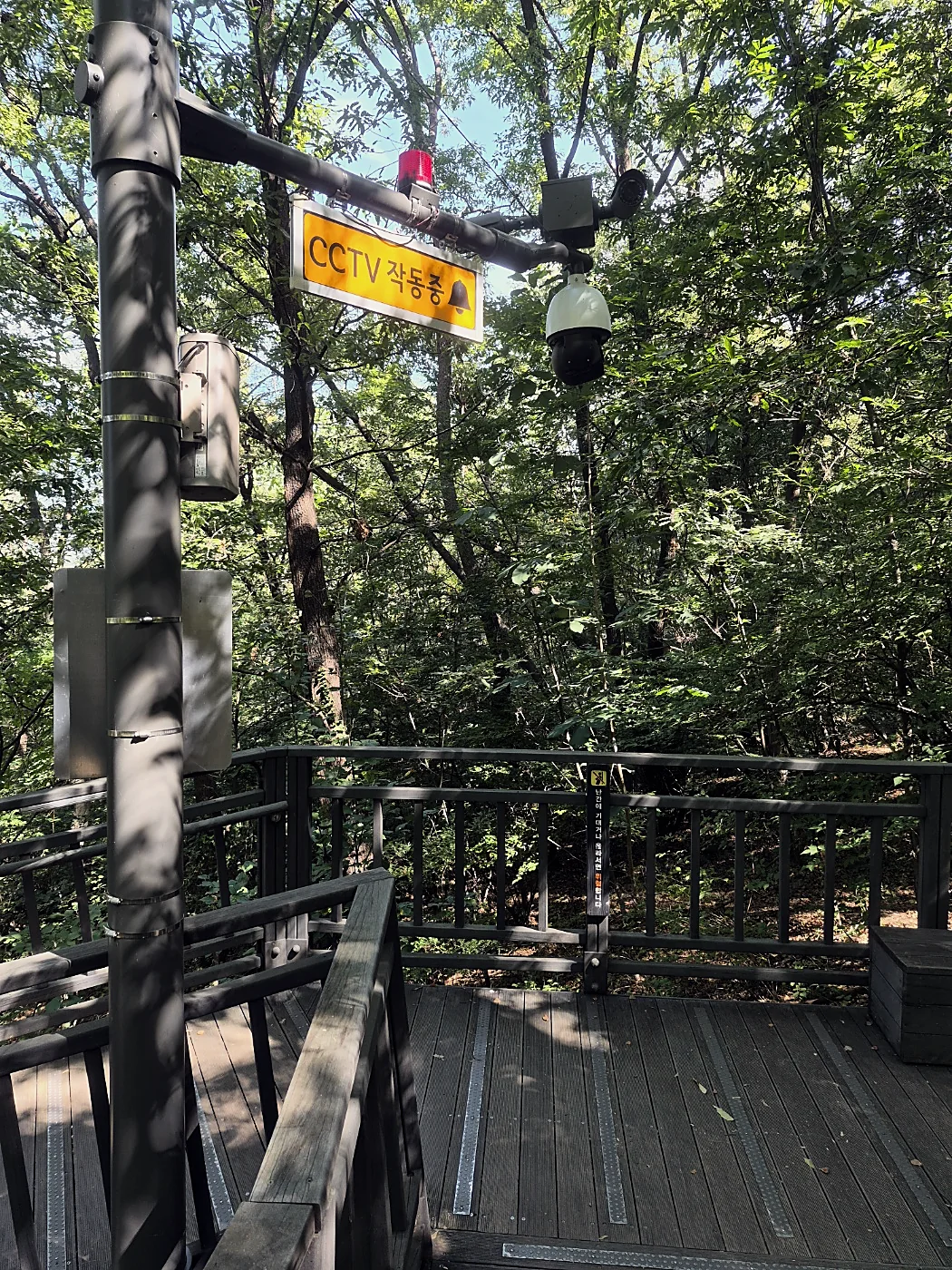 Seoul Trail Course 4: Mangu-Yongmasan 15 CCTV camera with a warning light above a forest deck path