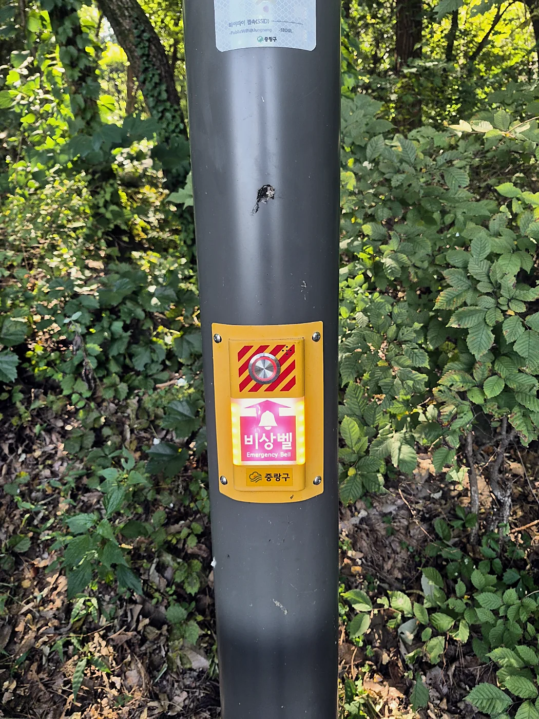 Seoul Trail Course 4: Mangu-Yongmasan 20 Pole with an emergency bell and a public Wi-Fi sticker